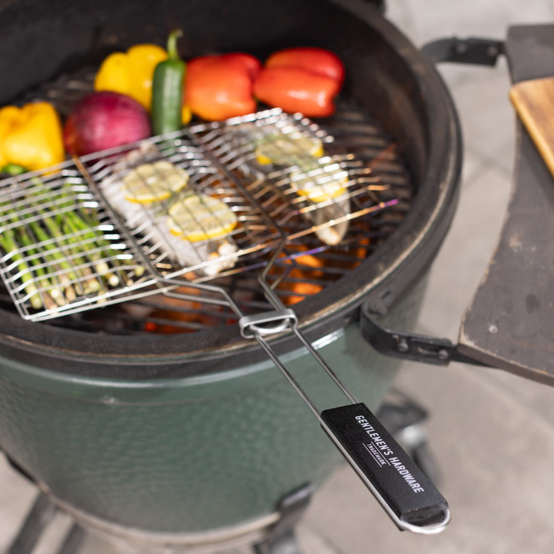 The Barbecue Grill Basket, made of green ceramic with a chrome grill, sizzles assorted vegetables and fish fillets over charcoal—perfect for any BBQ menu.