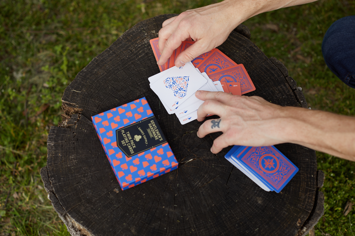 Gentlemen's Hardware Twin Pack Playing Cards on a log.