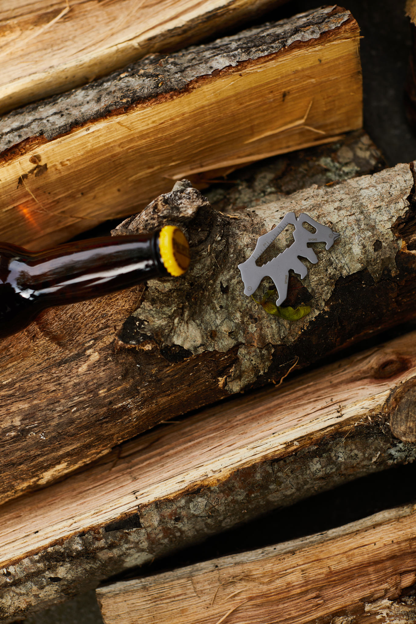 The bear multi-tool sitting on a pile of chopped logs.