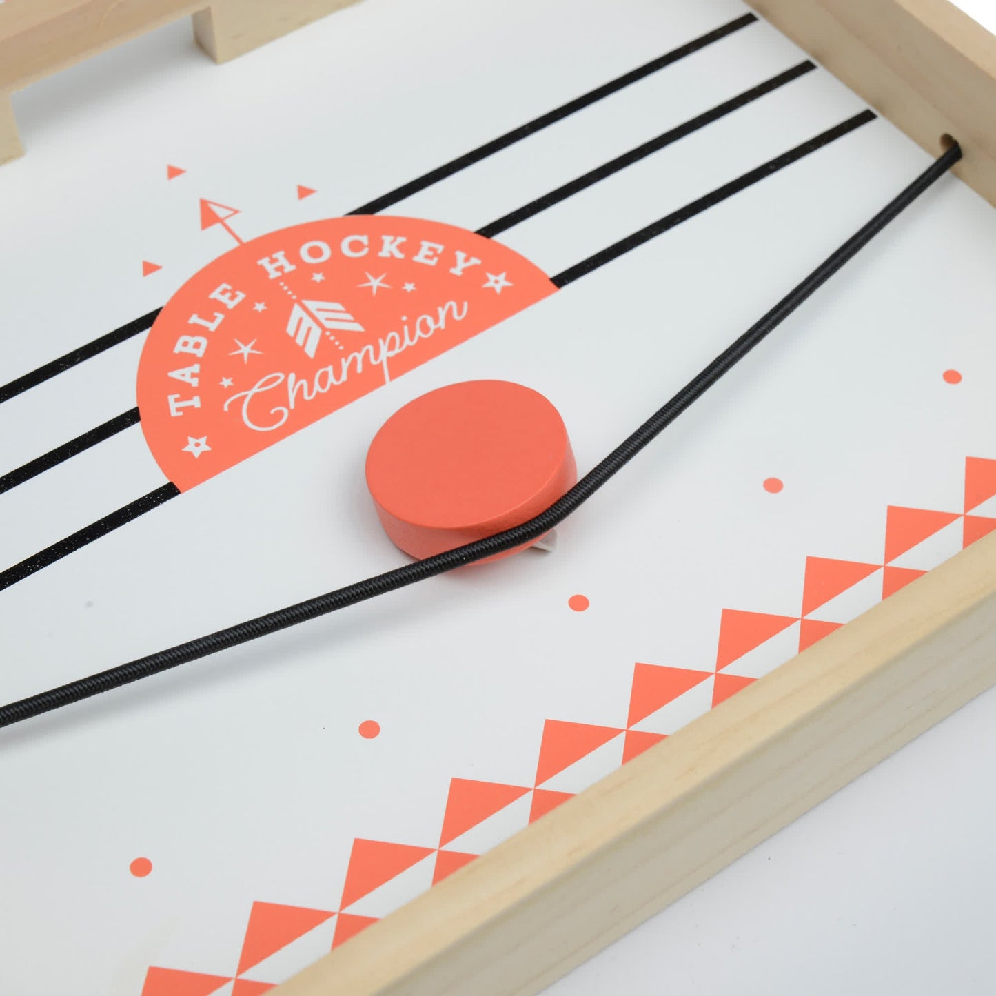 Table Hockey features a wooden board, black elastic bands as launchers, and an orange puck on a white surface labeled Table Hockey Champion.