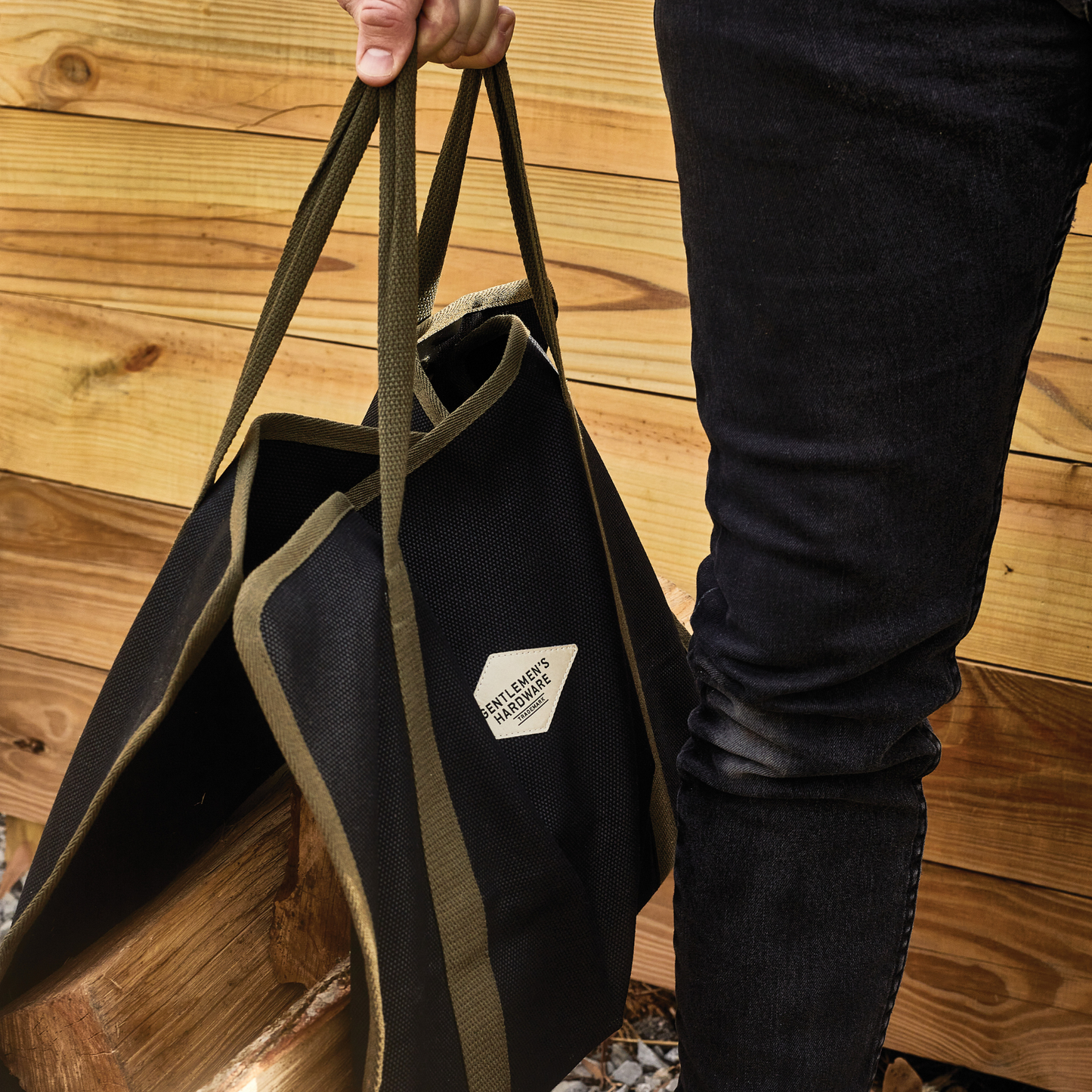 navy and green canvas log carrier filled with wood