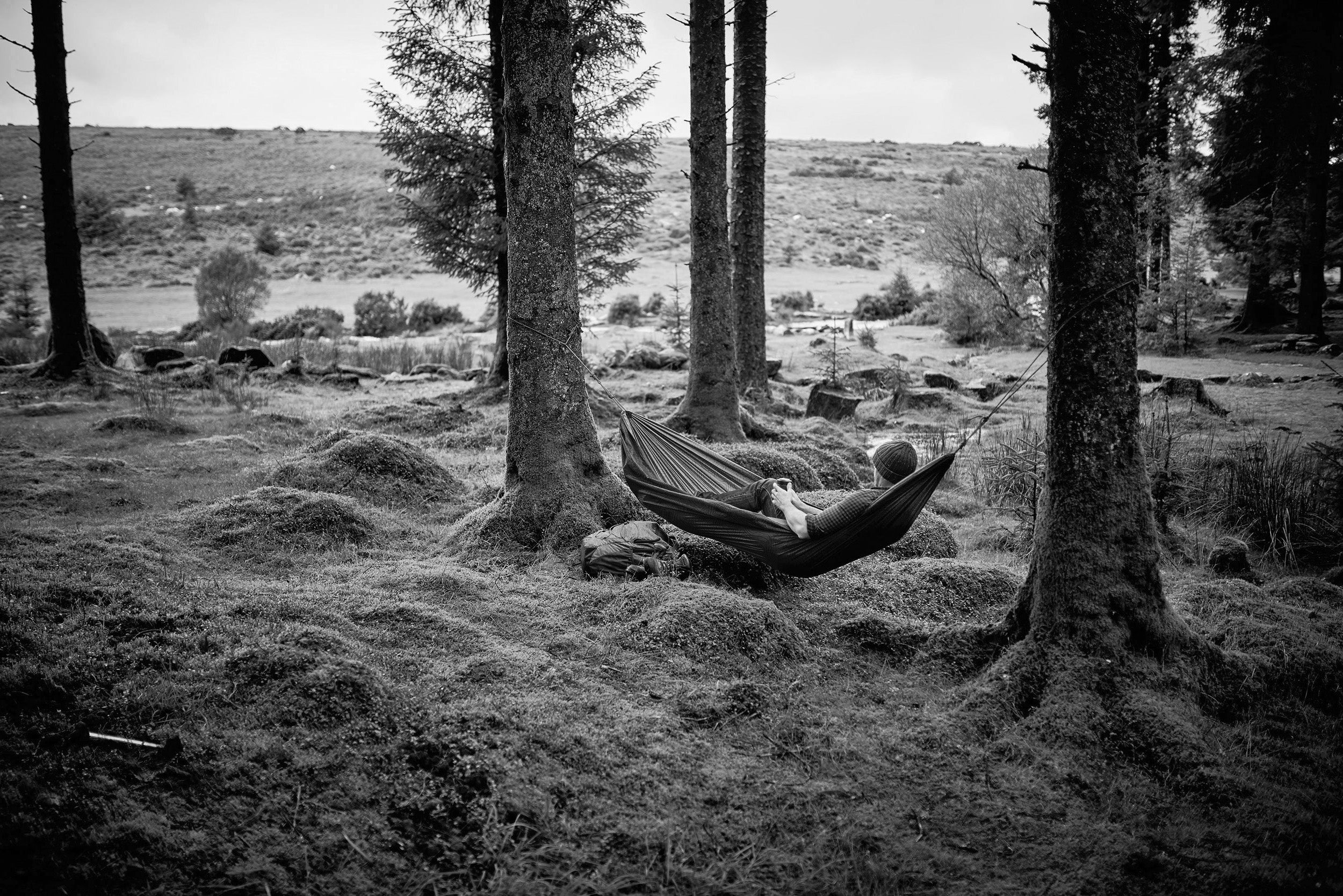 A person laying on a Hammock outdoors