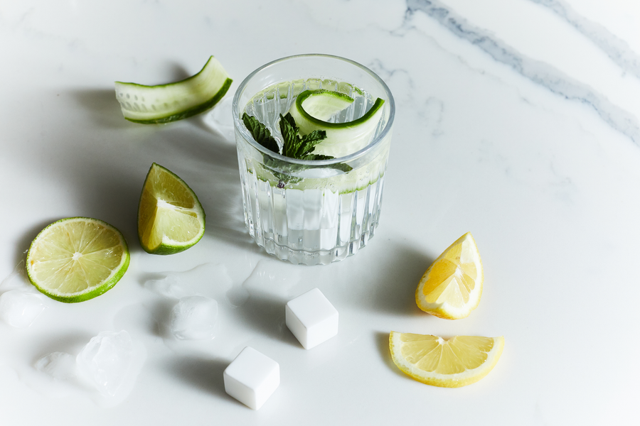 Gin stones on a marble table with lemon lime and cocktail glass