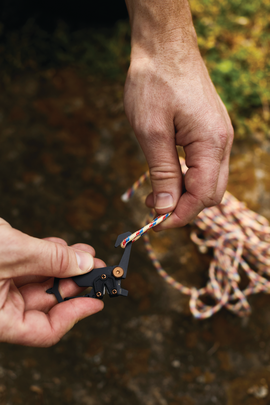 A person running rope through the Explorer multi-tool. 