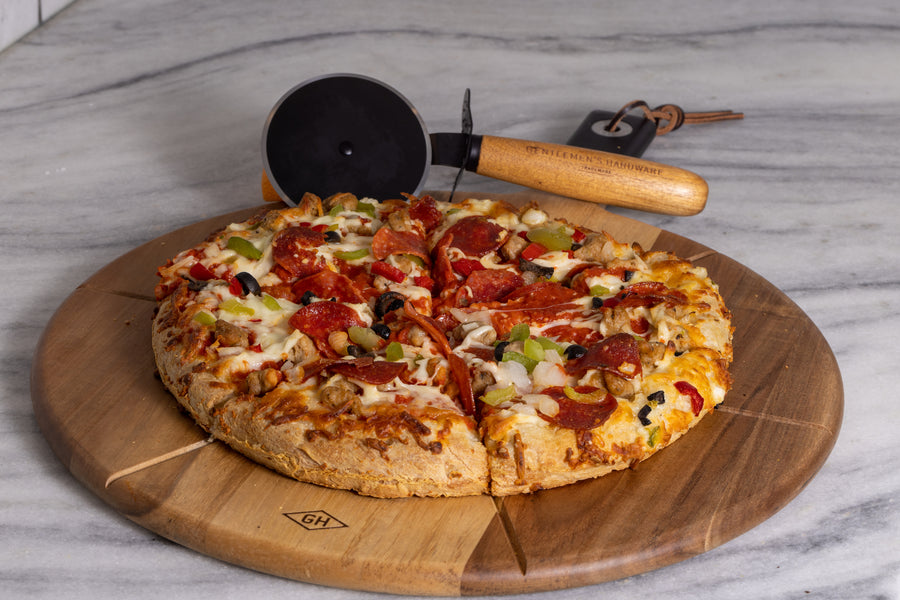 Pizza Cutter and Serving board with a supreme pizza on the board baked and ready to eat