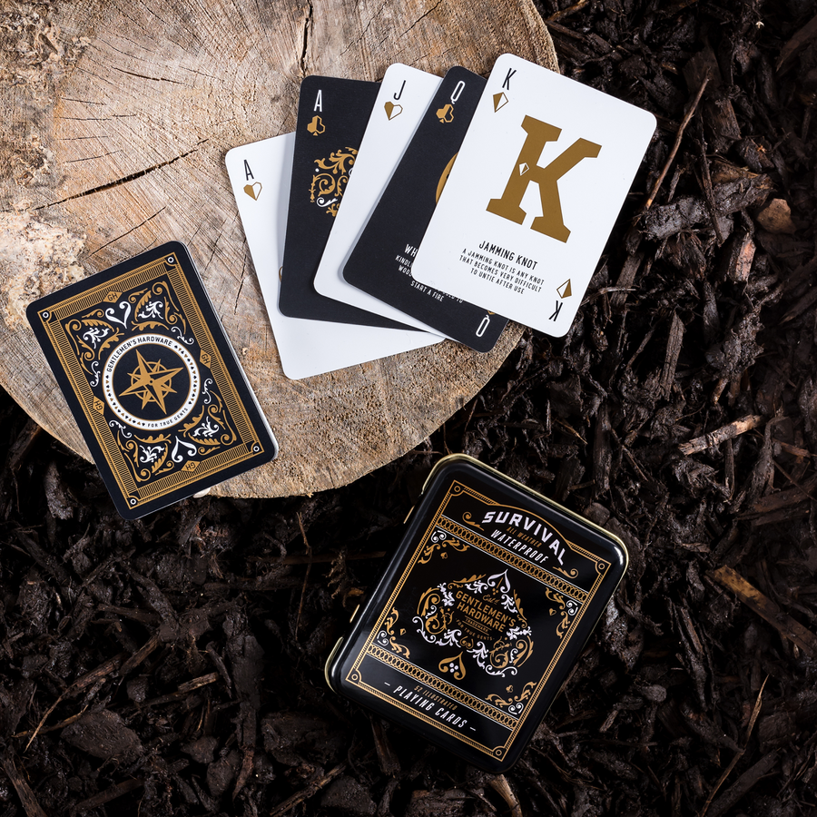 Survival Playing Cards displaying white and black playing cards with gold details and survival tips