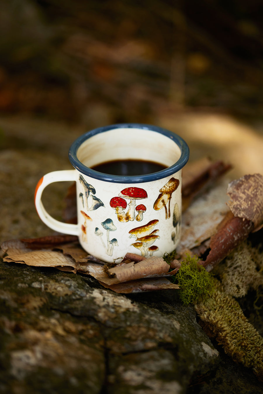 Enamel Mug - Mushroom 17 fl oz filled with coffee in wilderness on bark shards 