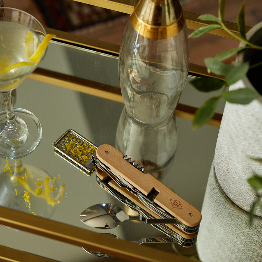 Kitchen multi tool on tray with cocktail shaker and martini glass