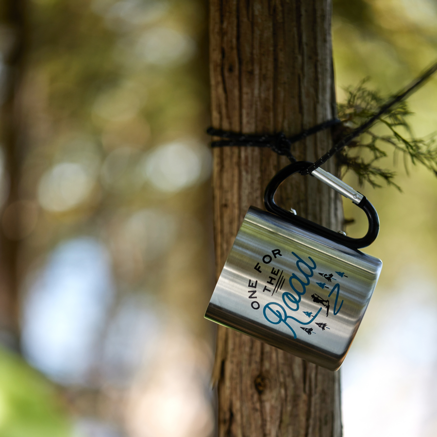 Carabiner Mug with text design reading One for the Road hanging from tent strap tied to a tree