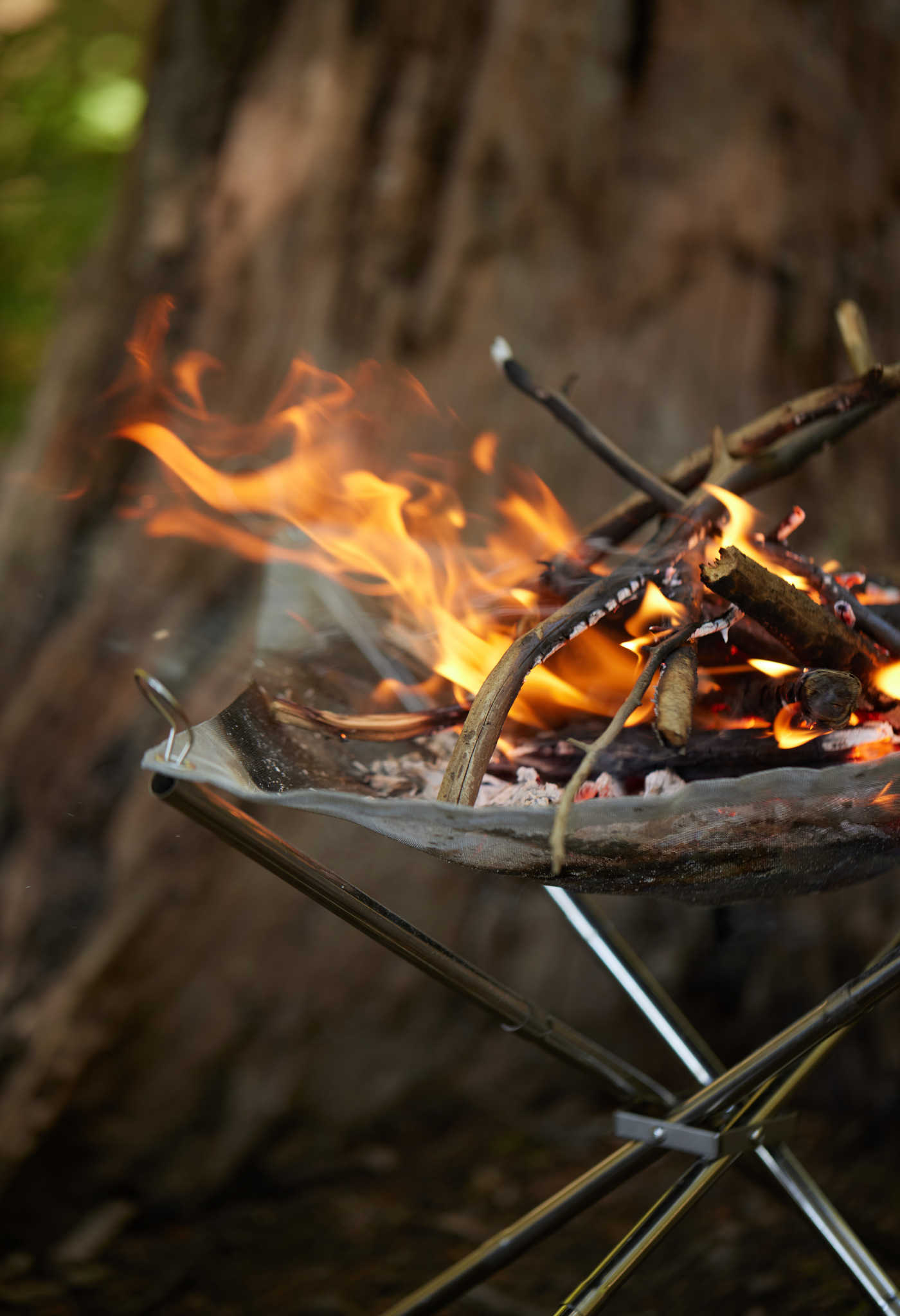 Collapsible Fire Pit close up shot with kindling burning on the pit